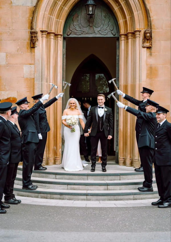 Bride and groom with bespoke wedding flowers by John Paul Florist